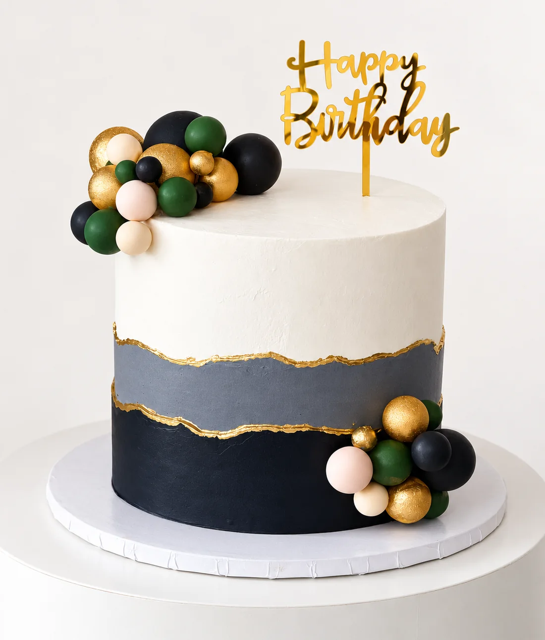 Cream, grey and black cake with gold edges and green, gold and blush ball clusters